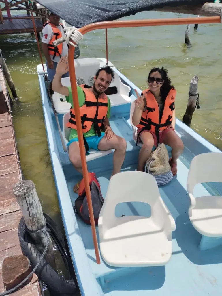 una pareja de italeanos empezando el recorrido de viajes sostenible en la bisosfera de ria lagartos, el guía le muestra que somo tour rio lagartos a lo que ellos responden con sonrisas y alegría