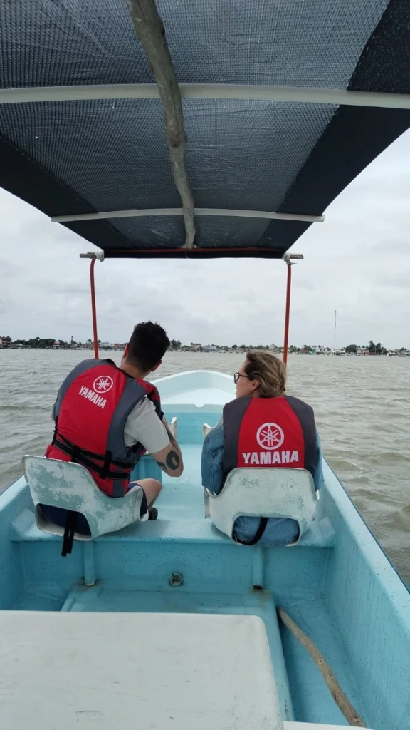 A couple wearing life jackets on a guided boat tour, looking out at the shoreline of the Rio Lagartos fishing village in Yucatan, Mexico. Rio Lagartos Couples Tour