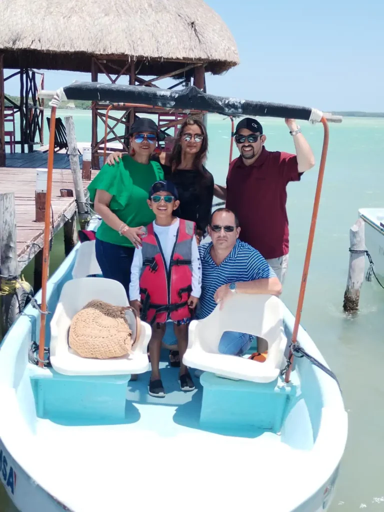 Creando Recuerdos: Nuestro Viaje Familiar a Río Lagartos 1 Familia sonriente con un niño posando para una foto en una lancha durante su viaje familiar a Río Lagartos, Yucatán.