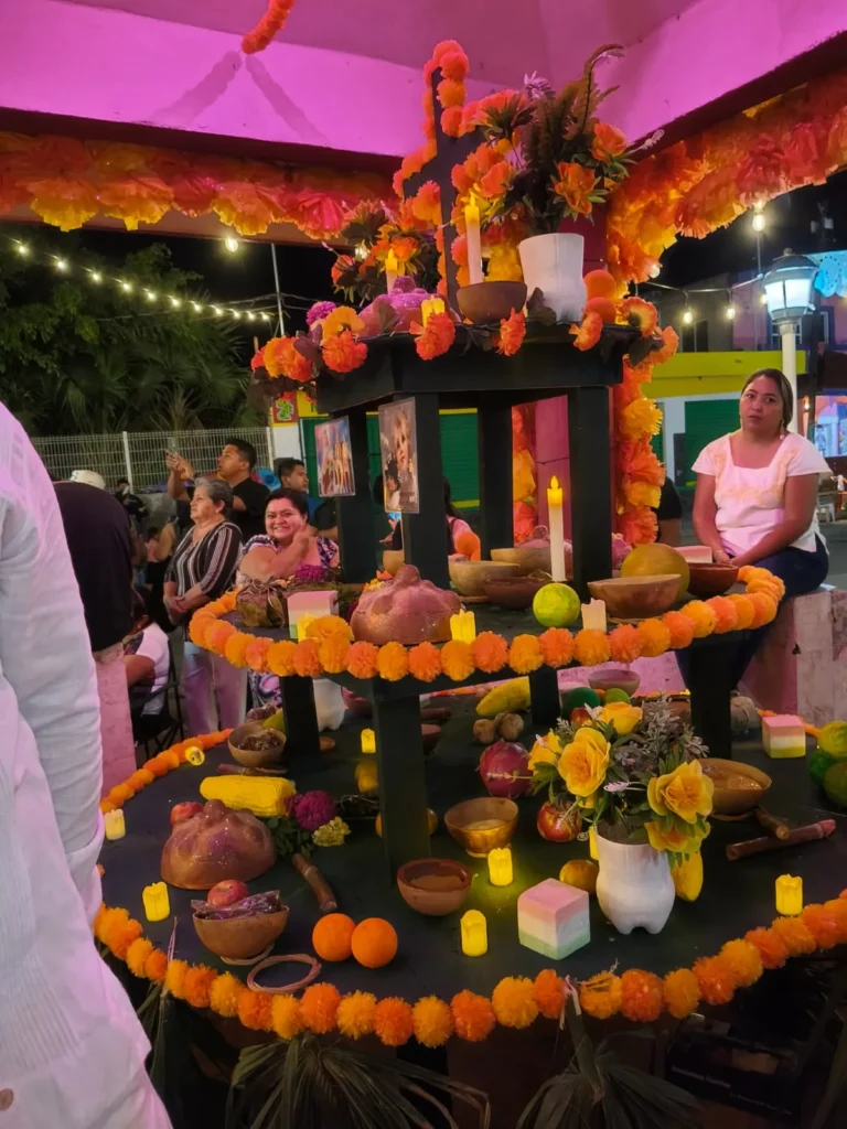 Altar de muertos tradicional de Hanal Pixán de varios niveles, adornado con flores de cempasúchil, velas, pan de muerto y fotografías durante el Festival de Ánimas en Río Lagartos.