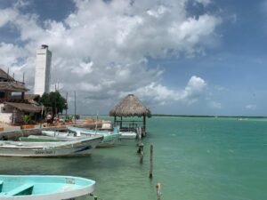 Private boat tour docking area in Rio Lagartos Yucatan, featuring clear turquoise water and the iconic white lighthouse.