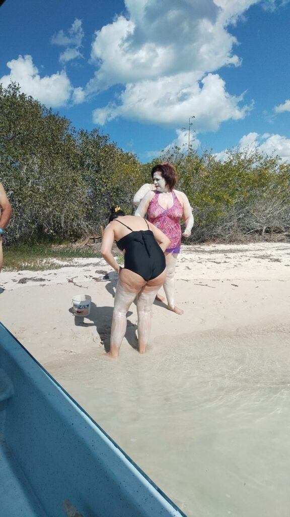 Tourists applying medicinal white mud to their skin during a mayan mud bath rio lagartos excursion in Yucatan.