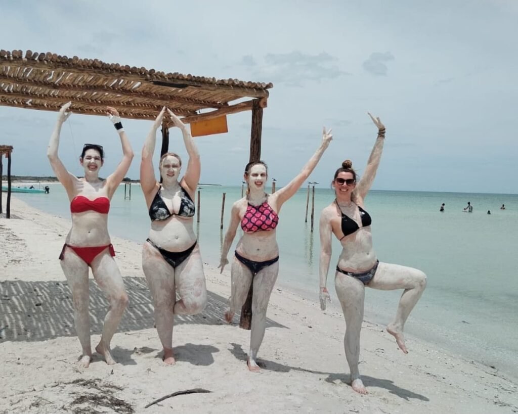Group of happy women posing with natural clay on their skin during an authentic about tour rio lagartos experience.