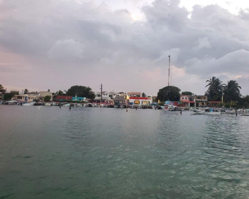 The Ultimate Guide Rio Lagartos Las Coloradas 7 Panoramic view of fishing boats docked along the local harbor town waterfront, featured on our Rio Lagartos Travel Blog.